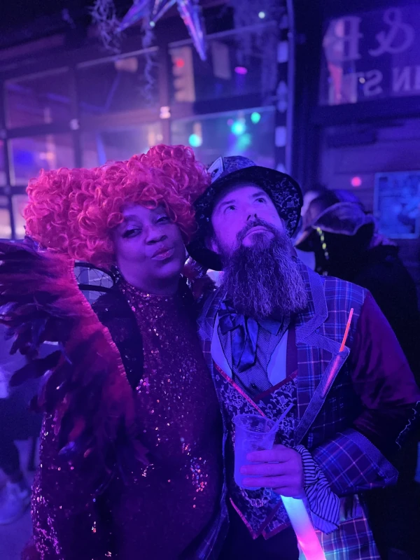 Two people posing together in the blue light of Speakeasy